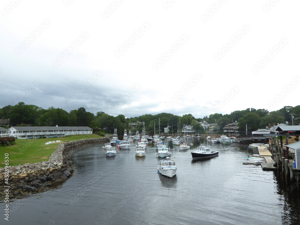 A view of a small town or a village on a cloudy day. Fishing boats along rocky water edge with houses around
