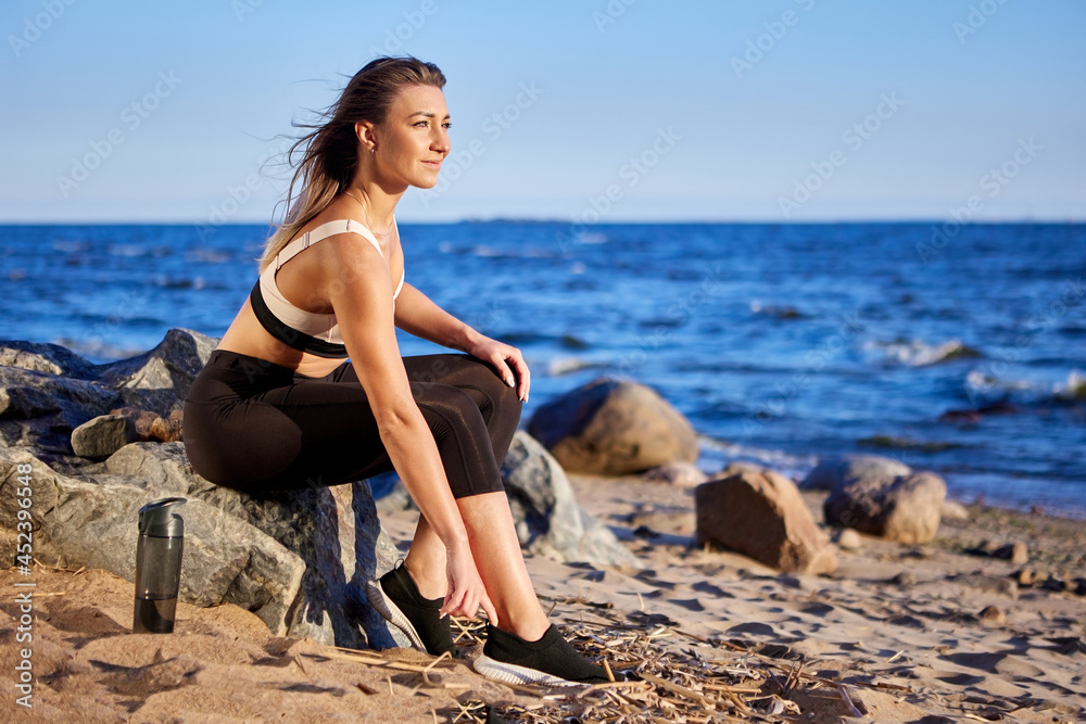 Woman on shore has rest during making exercises.