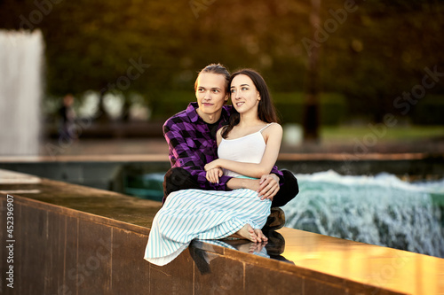 Couple has date in park near fountain.