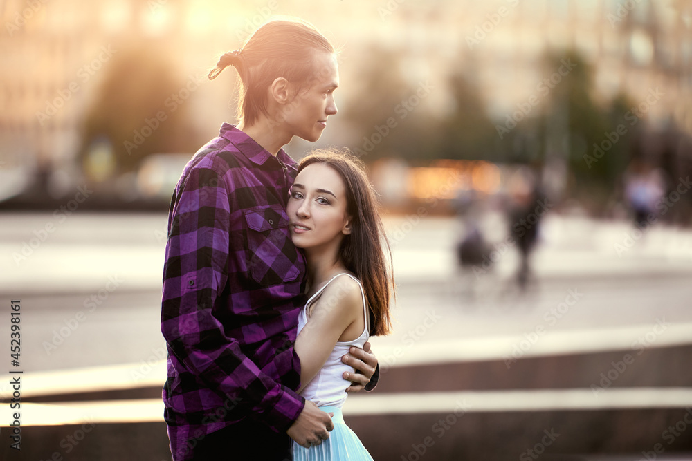 Young man hugs woman during date in park. Young man hugs woman during date in park.