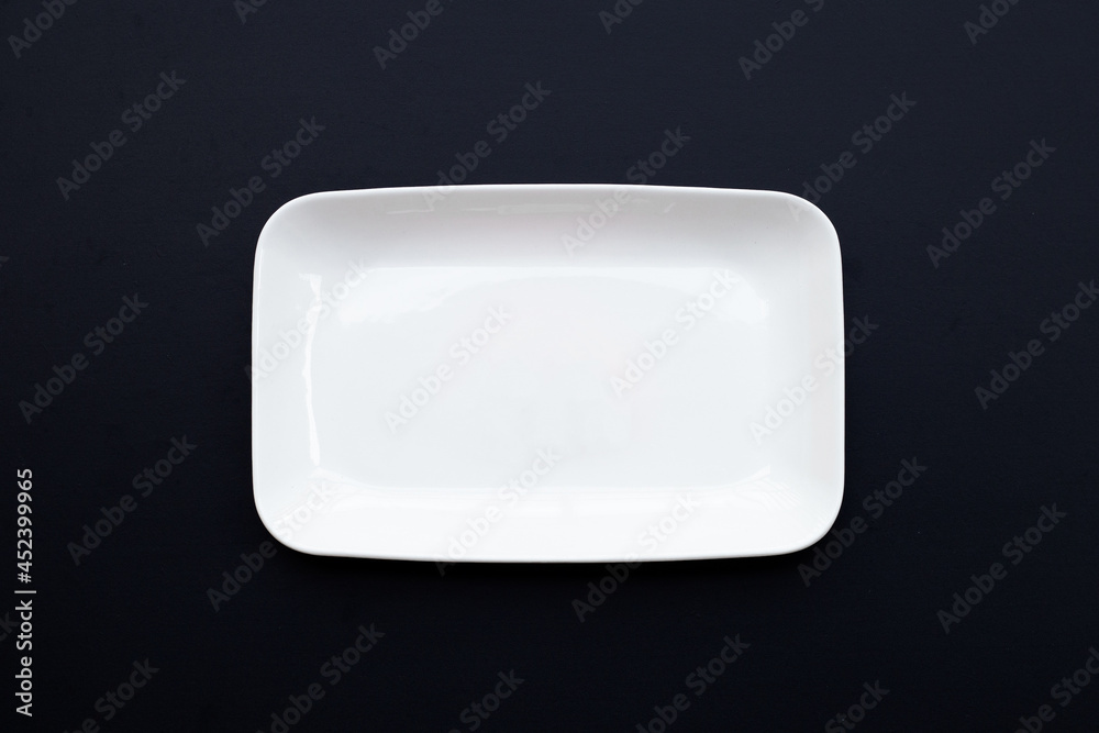 Empty white dish plate on dark wooden background. Empty white dish plate on dark wooden background.