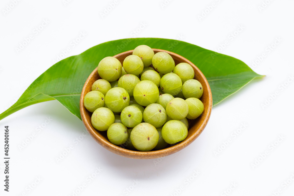 Fresh emblica in wooden bowl on white background. Fresh emblica in wooden bowl on white background.