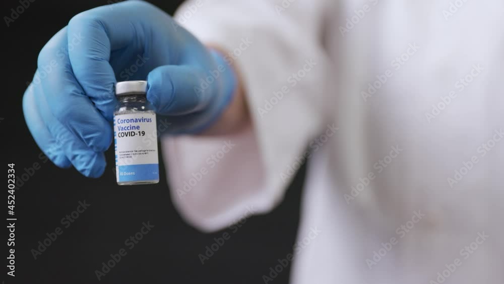 A Doctor's Hand Presents A Vial of Vaccination A Doctor's Hand Presents A Vial of Vaccination