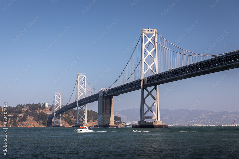 Landscape of San Francisco - Oakland bay bridge with running boat.