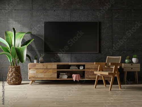 Loft space empty room with tv and cabinet on dark concrete interior background.