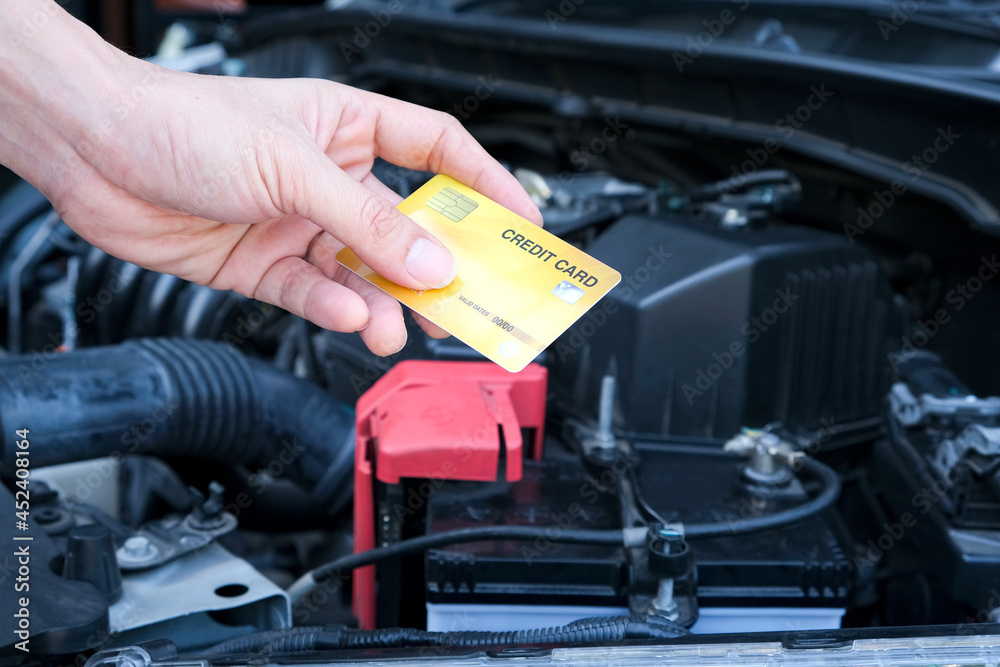 Young man's hand Blue credit card machine holding automobile background Young man's hand Blue credit card machine holding automobile background