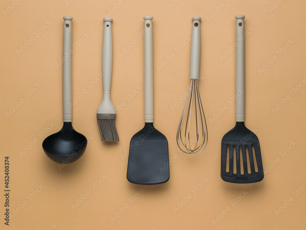 Black and beige kitchen accessories on a brown background. Flat lay. Black and beige kitchen accessories on a brown background. Flat lay.