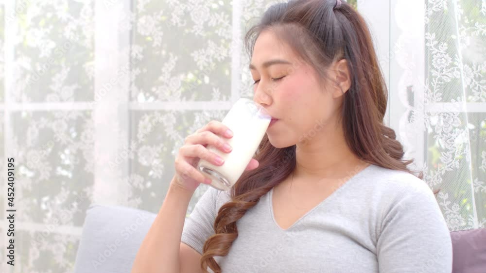 Healthy Young Asian woman Drinking milk with calcium for strong bone at home,Smiling indian woman holding soy milk on glass enjoy with nutrition wellness life,Wellness with natural milk fresh Concept Healthy Young Asian woman Drinking milk with calcium for strong bone at home,Smiling indian woman holding soy milk on glass enjoy with nutrition wellness life,Wellness with natural milk fresh Concept
