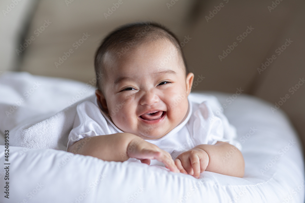 Adorable Asian baby girl lying on bed looking at camera.Cute little baby smiling and happiness relaxing in bed.Portrait of asian baby newborn in bedroom Adorable Asian baby girl lying on bed looking at camera.Cute little baby smiling and happiness relaxing in bed.Portrait of asian baby newborn in bedroom