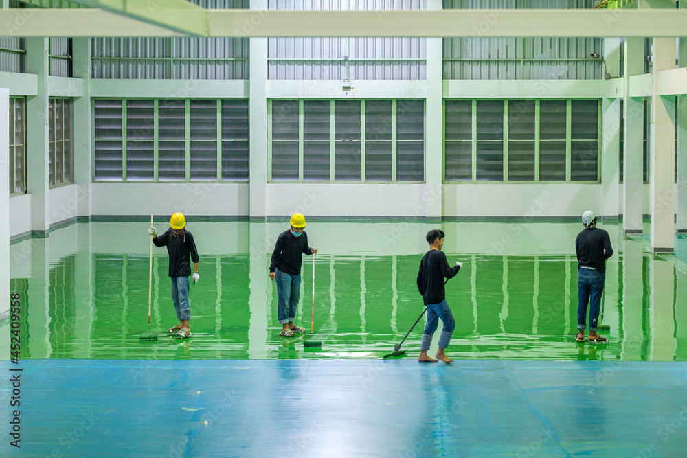 Foto de Construction workers are using rollor spreading green epoxy