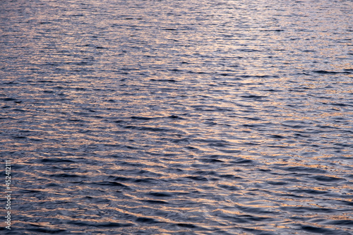 Gold water texture. Lot of waves on lake surface on sunset time..Natural summer background. Ripples, small, little wave.