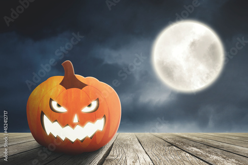 Creepy pumpkin on table with full moon background