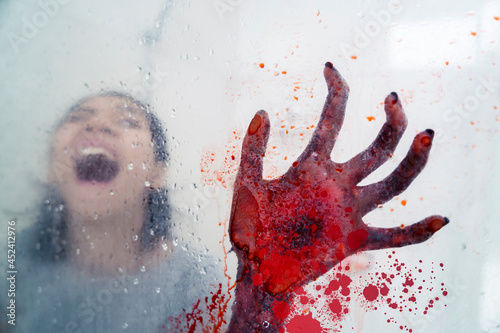 Screaming woman haunted by bloody hand