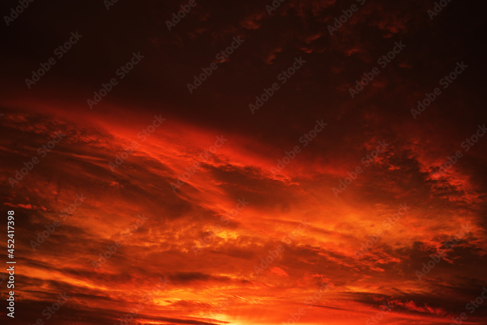 Red sky with clouds. Fiery red sunset background with copy space for design. Horror, cataclysm, armageddon, war, terror, terrorism, disaster, end of the world, concept.