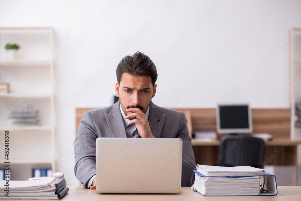 Young male employee working in the office Young male employee working in the office