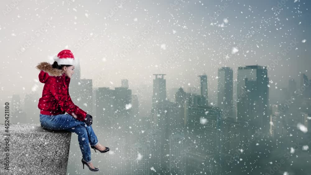 Young woman wearing santa hat on the rooftop house Young woman wearing santa hat on the rooftop house