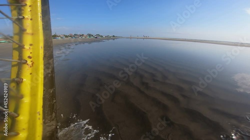 Action Cam POV, Bicycle Wheel Splashing Ocean Water Onto Camera On Coastal Beach photo