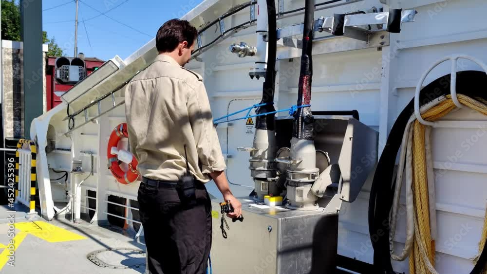 Ships crew disconnecting and hoisting charging cables after fully charging batteries onboard