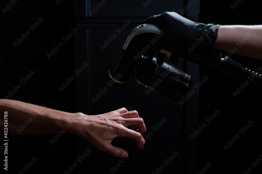 Naklejka premium The master applies tinting paint to the woman's hand. Instant tanning procedure