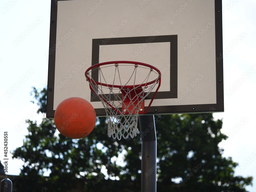 ball flies into the basketball hoop on the street during the game ball flies into the basketball hoop on the street during the game