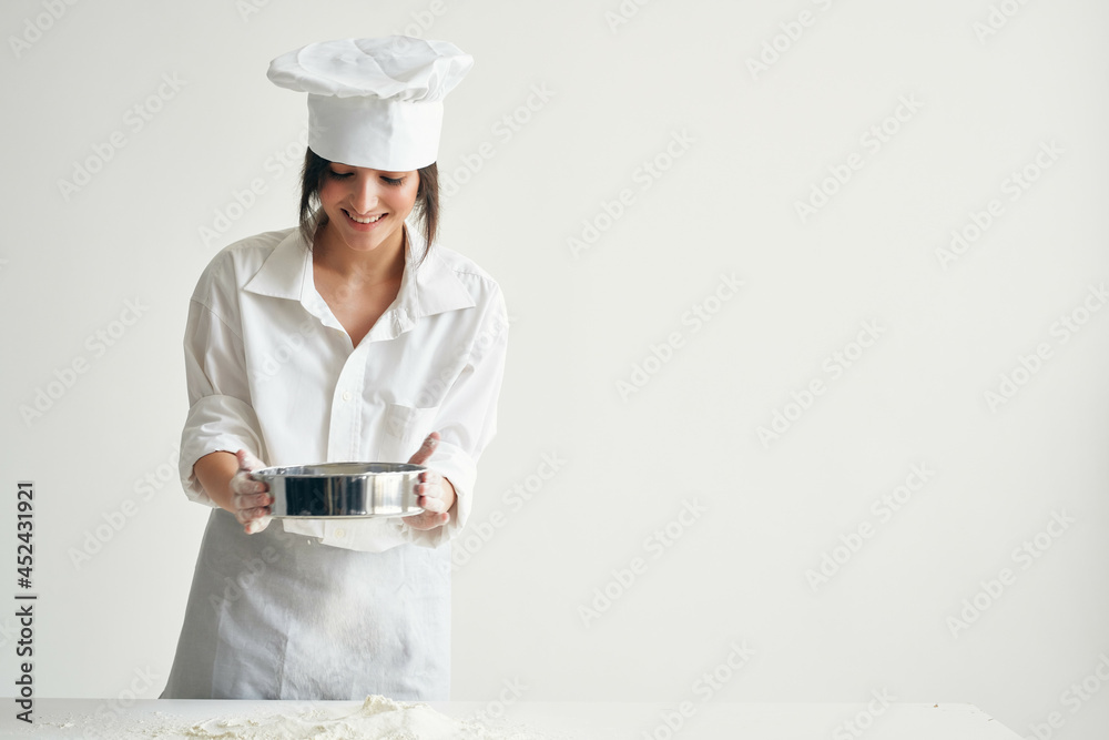 woman baker sift flour working with dough Professional woman baker sift flour working with dough Professional