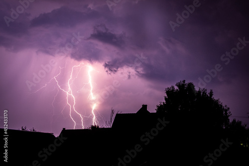 Multiple lightning strikes painting the sky purple on a summer evening during a thunderstorm