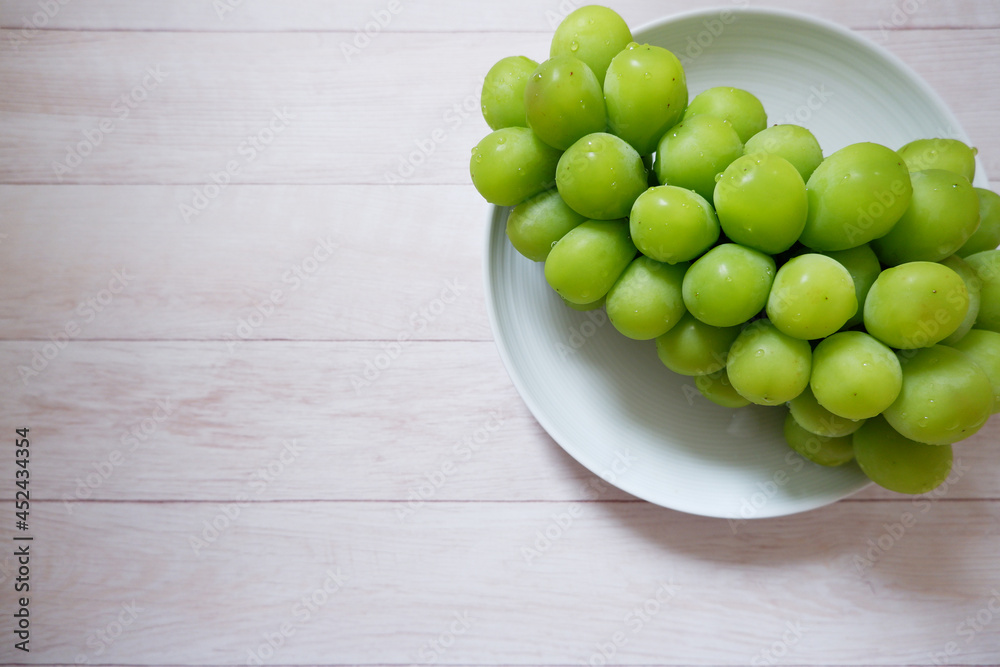 Fresh Muscat on white wooden background. Shine Muscat, Fresh grape. Green fresh grape with water drops.