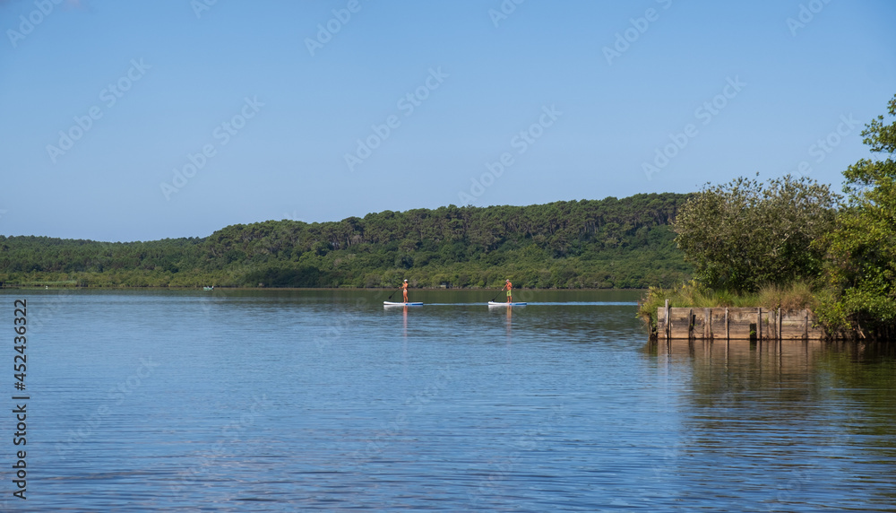 Dos personas haciendo paddle sup en un lago de Francia.