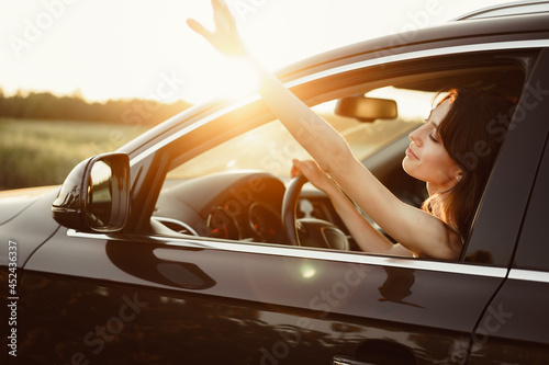 Beautiful smiling woman driving her car in the morning