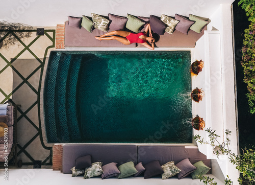 Aerial view of an attractive young woman sunbathing in a red swi photo