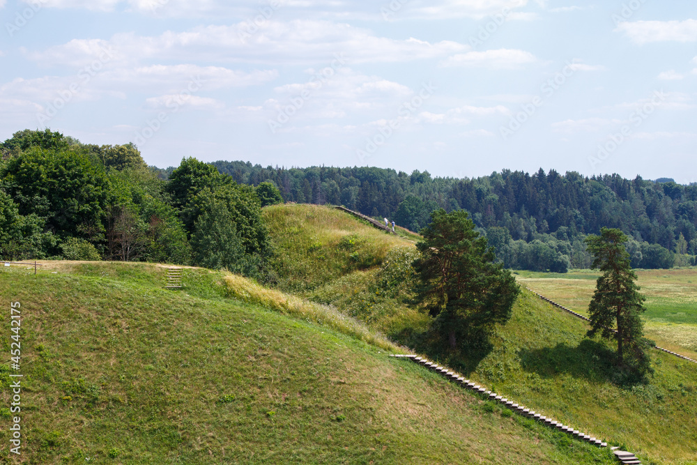 Hilly country. Walking paths up the mountain. Kernavė, site of the ancient city. High hills by the river. Wooden staircase to the mountain. The famous Lithuanian landscape.