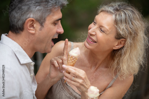 happy mature attractive middle-aged couple eating ice cream