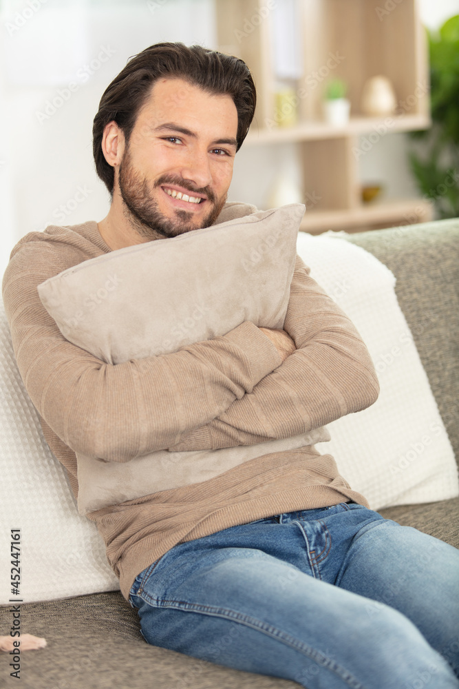 man lying on back on sofa in bright living room