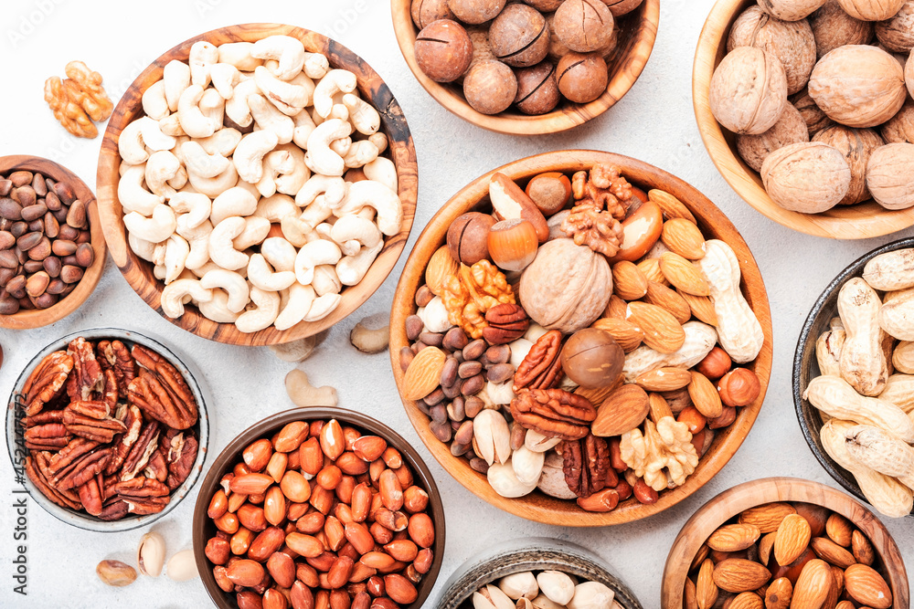 Nut mix in bowl. Almonds, hazelnuts, walnuts and other. Healthy food snack mix on white table, top view Nut mix in bowl. Almonds, hazelnuts, walnuts and other. Healthy food snack mix on white table, top view