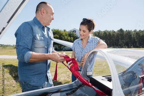 young couple talking next to lightweight airplane