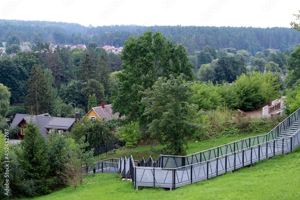 Pedestrian terrace, ramp - descent from the hill to the river. Metal structure on the hill.