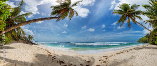 Fototapeta Naklejka Na Ścianę i Meble -  Panorama of Sunny beach with palms and turquoise sea.  Summer vacation and tropical beach concept.  