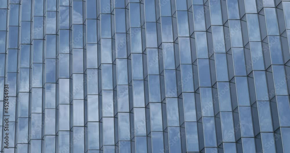 Sky and clouds reflecting in the windows of a modern glass skyscraper