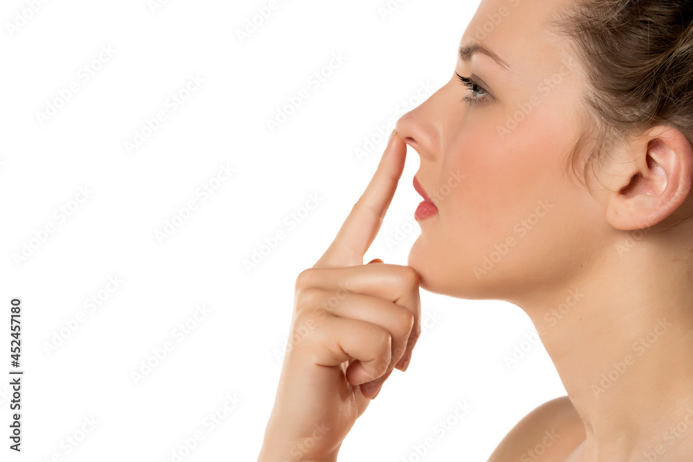 profile of a blonde serious woman touching her nose profile of a blonde serious woman touching her nose