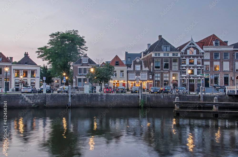 Zwolle, The Netherlands, August 5, 2021: view across Thorbecke canal at twilight with street lanterns and historic houses