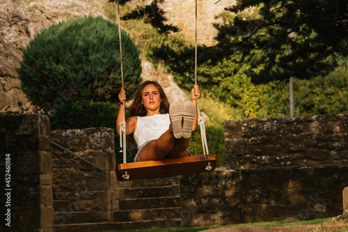 Gorgeous blonde woman enjoying on the swing during golden hour