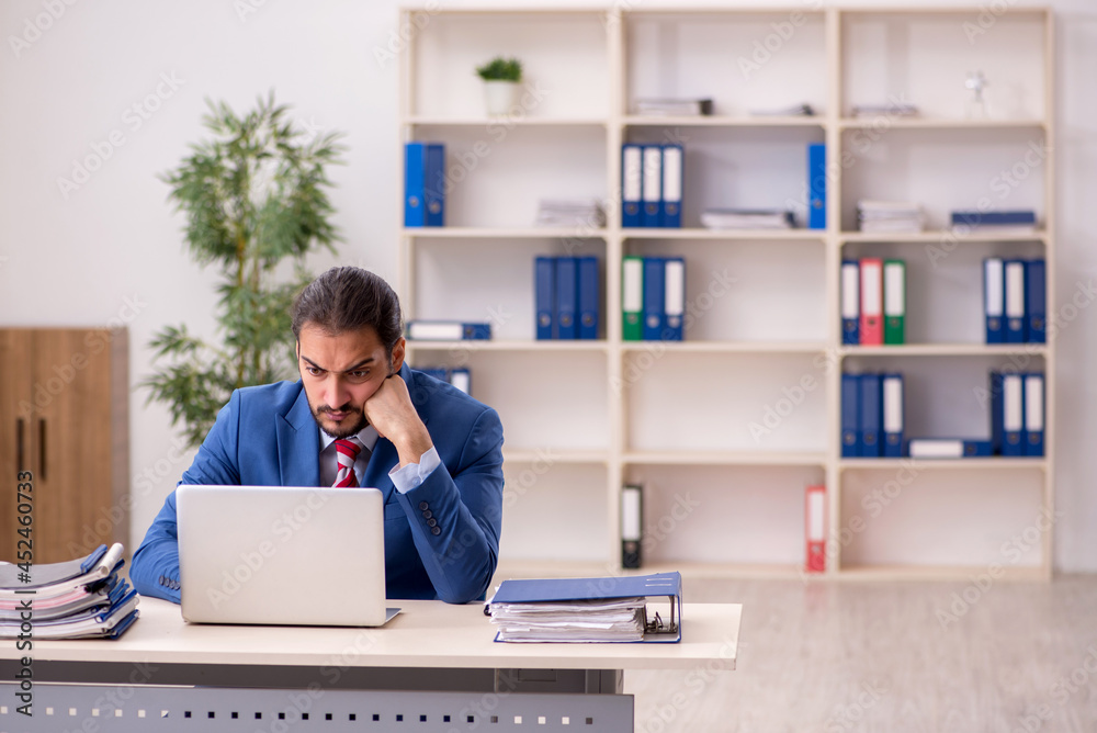 Young male employee working in the office Young male employee working in the office