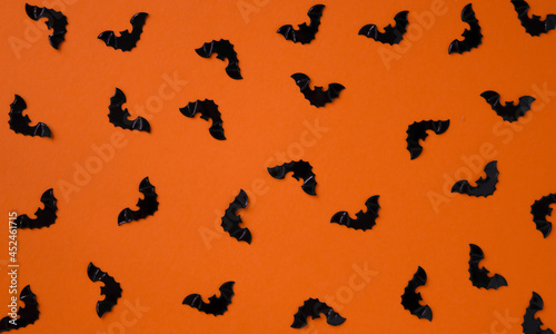 Black bats on an orange background. Halloween pattern. Background for design .