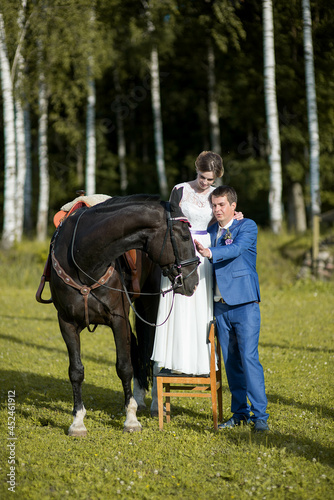 Happy wedding couple with dark horse