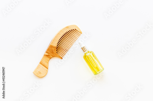 Essential oil for hair care with wooden hair comb