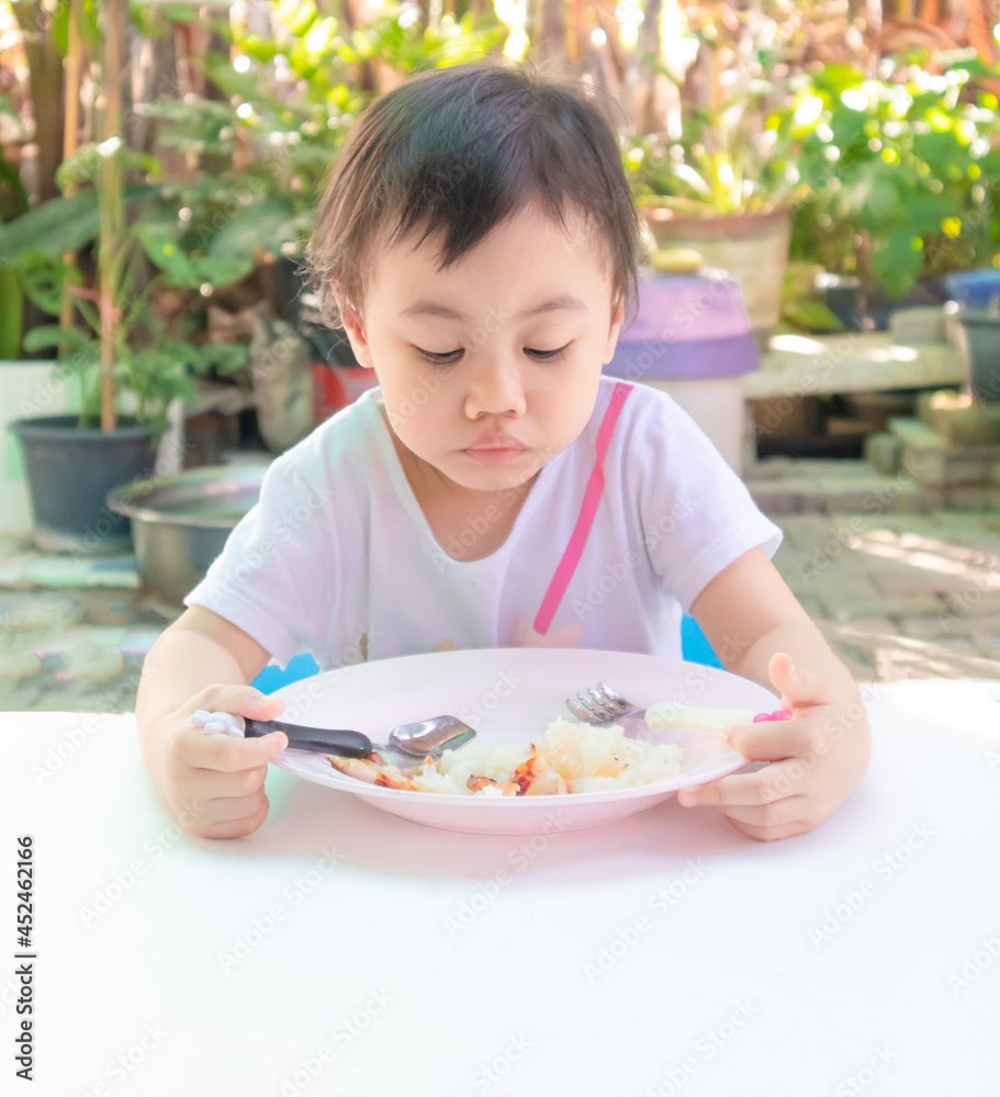 Asian little girl eating tasteless food for lunch, loss of appetite. Asian little girl eating tasteless food for lunch, loss of appetite.