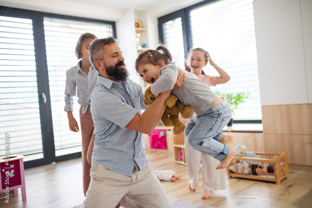 Father with three daughters indoors at home, playing on floor. Father with three daughters indoors at home, playing on floor.