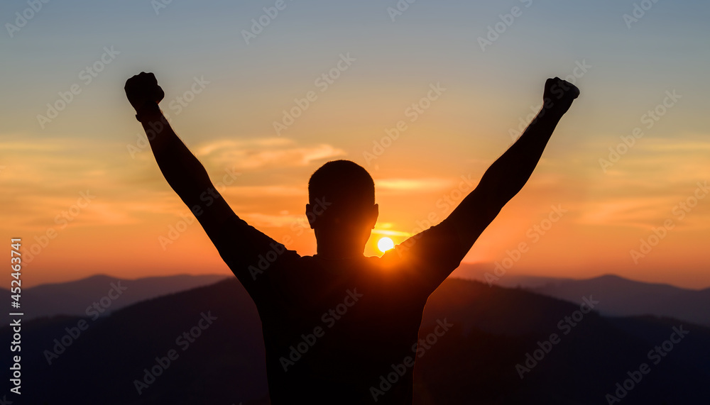 Free man raising arms to golden sunset summer sky. Freedom, success and hope concept