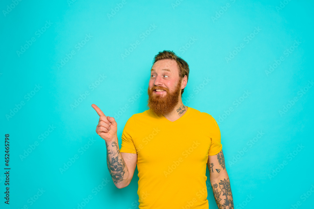 Man with yellow t-shirt and beard is shocked about something Man with yellow t-shirt and beard is shocked about something
