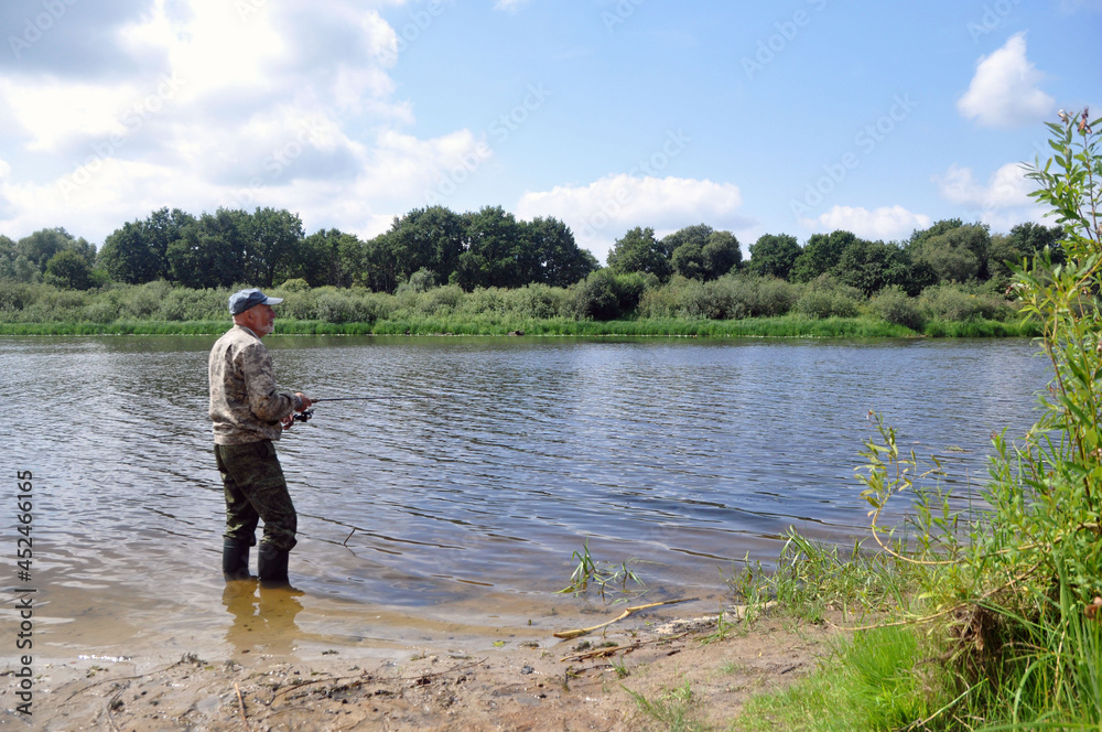 A fisherman is fishing in the river from the bank for spinning. A fisherman is fishing in the river from the bank for spinning.